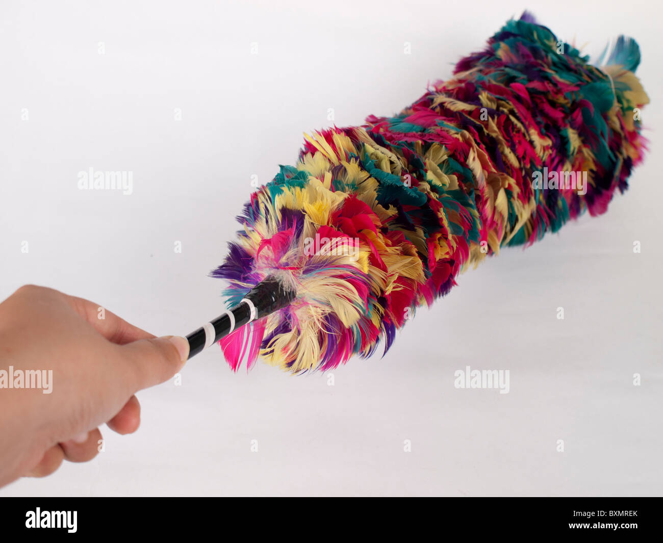 Magd Hand mit einem Multi Farbe Staubtuch Reinigung Staub Huhn Feder Stockfoto