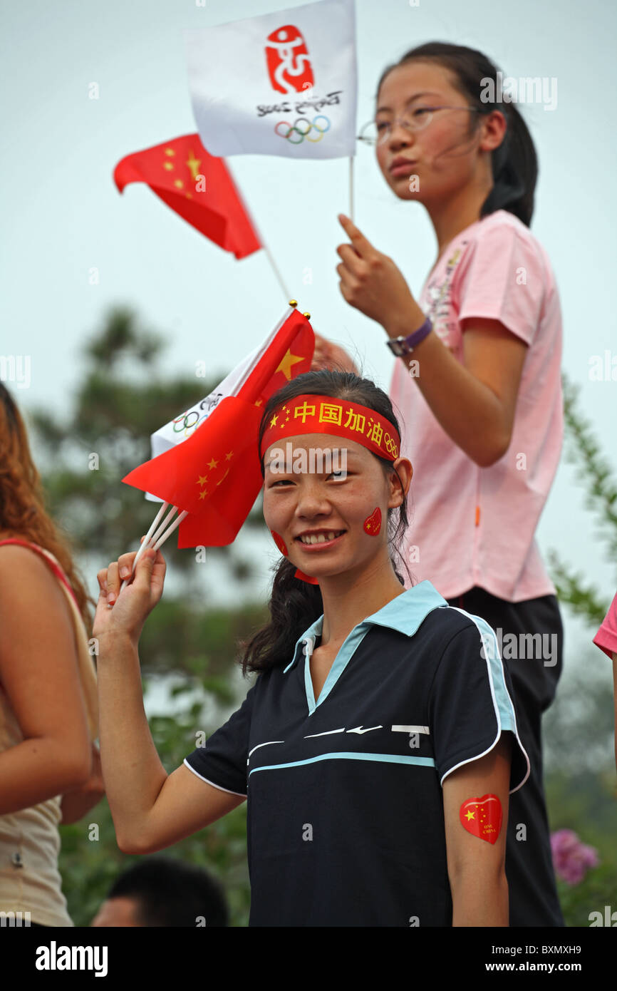 Chinesische Mädchen winken Nationalflaggen bei der Parade vor den Olympischen Spielen, Peking, China Stockfoto