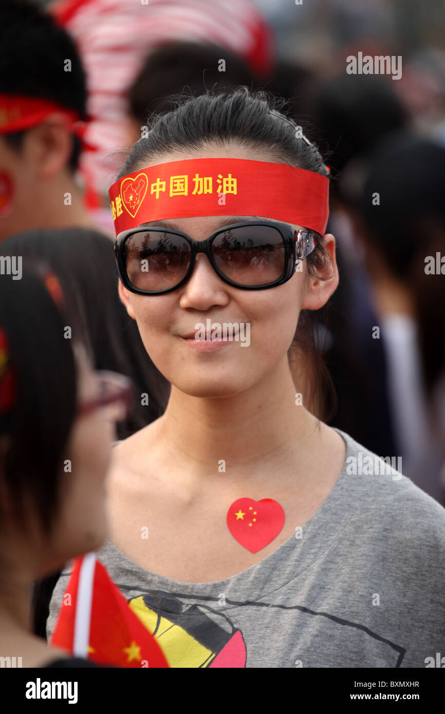 Chinesische Frau, die die Parade vor den Olympischen Spielen beobachtet, Peking, China Stockfoto