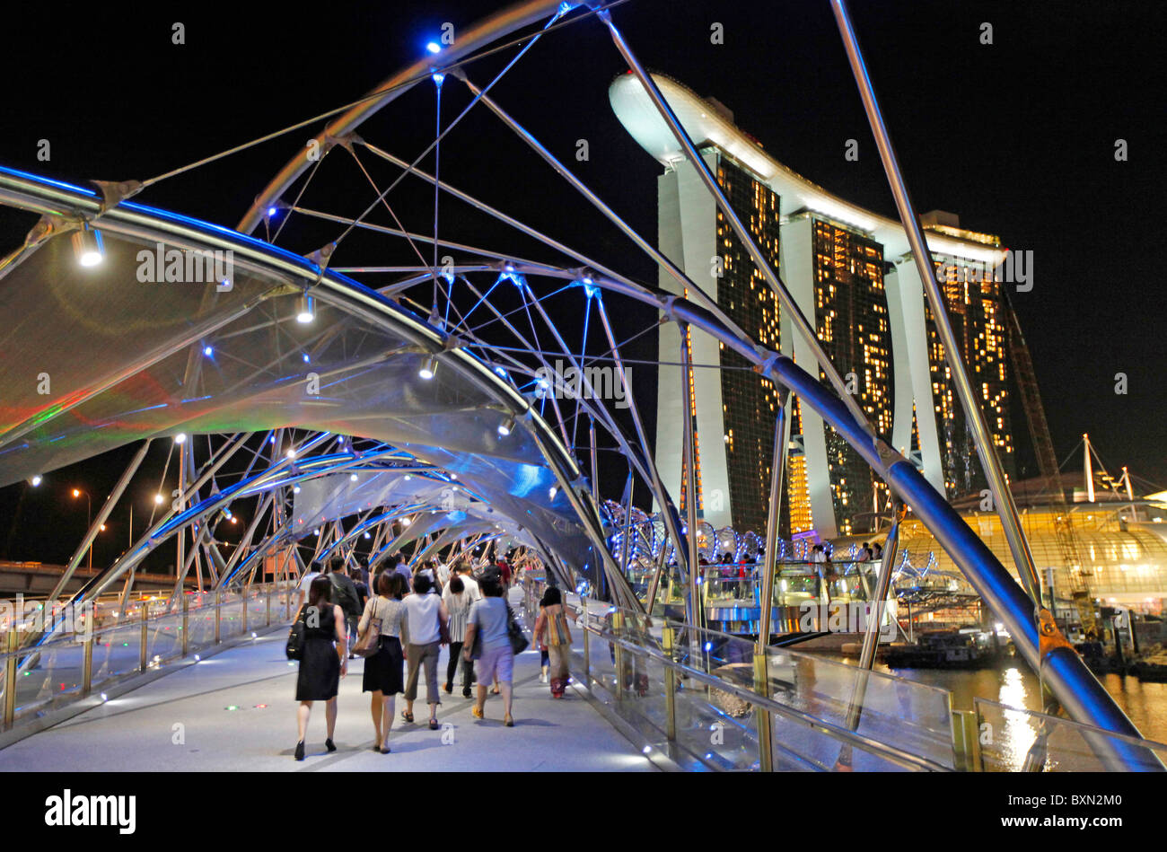 Singapur: Die Helix-Brücke in der Nacht mit Marina Bay Sands Resort Hotel und Einkaufszentrum in der backgrounnd Stockfoto