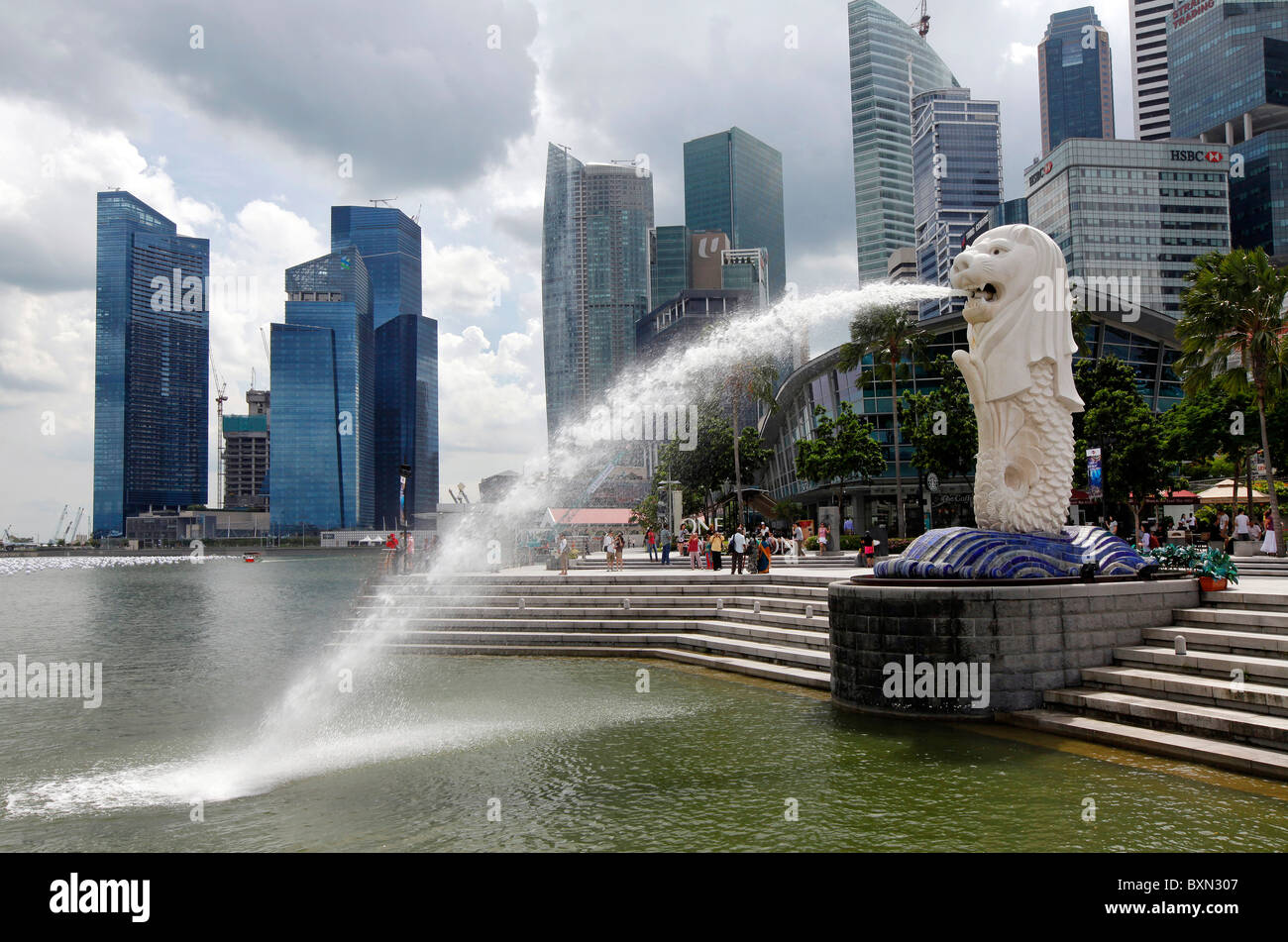 Singapur: der Merlion Statue mit Skyline der Stadt im Hintergrund, Marina Bay Esplanade Stockfoto