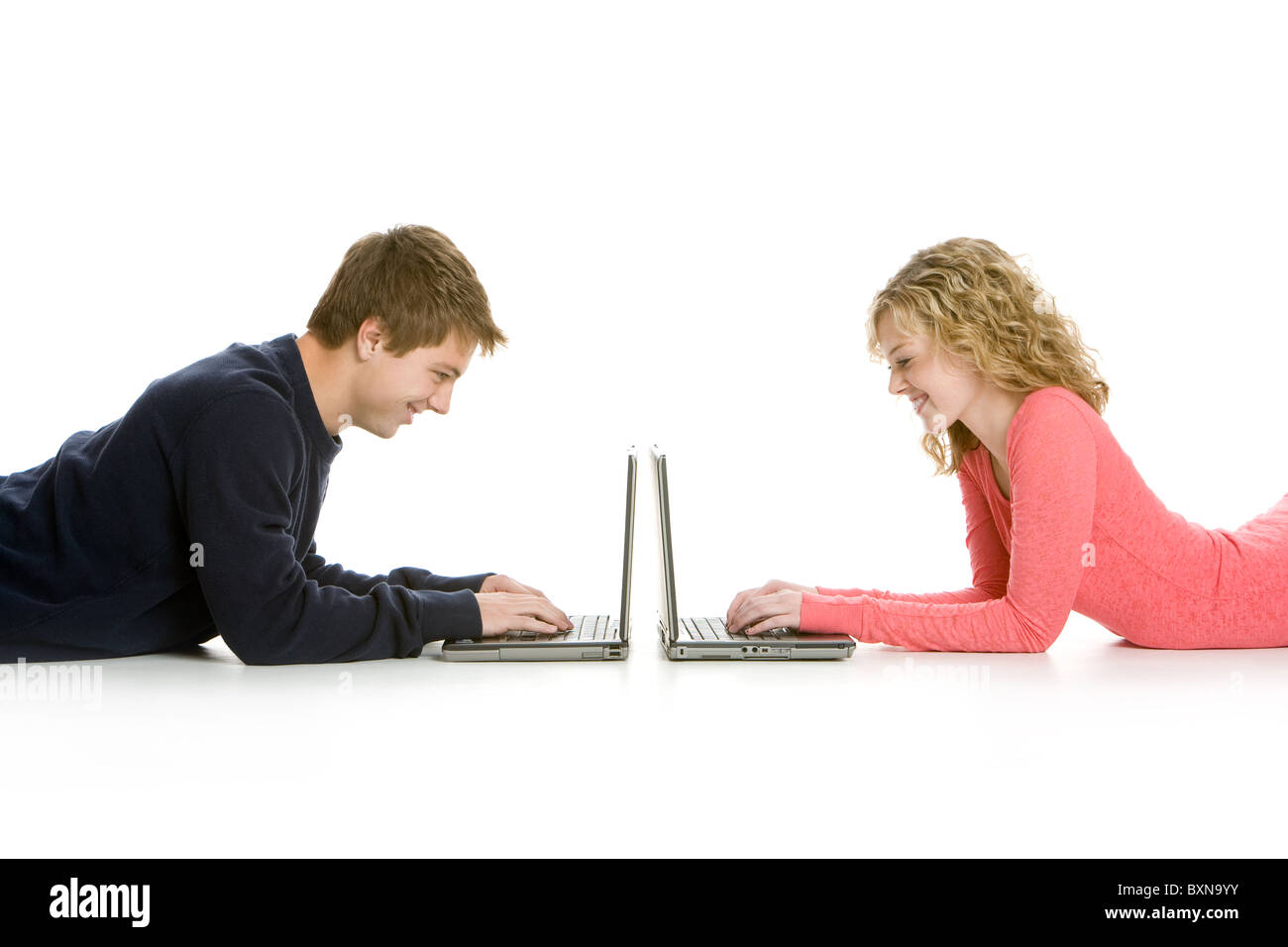 Attraktive Teenager liegend mit Laptops isoliert auf weißem Hintergrund Stockfoto