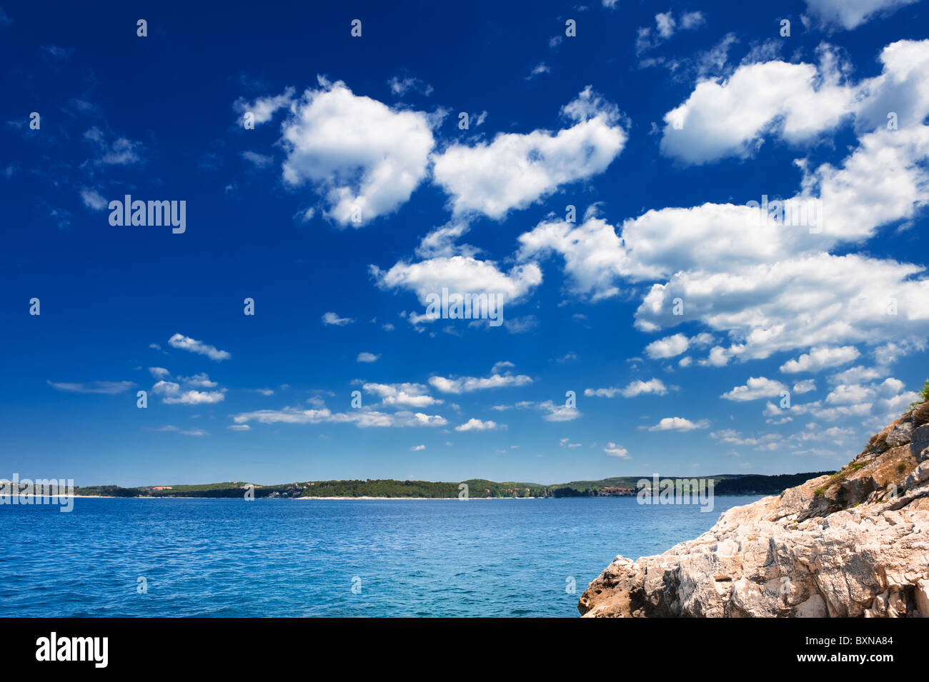 Adria Küste unter blauem Himmel. Steiniger Strand Rovinj - beliebtes Touristenziel an der kroatischen Küste. Stockfoto