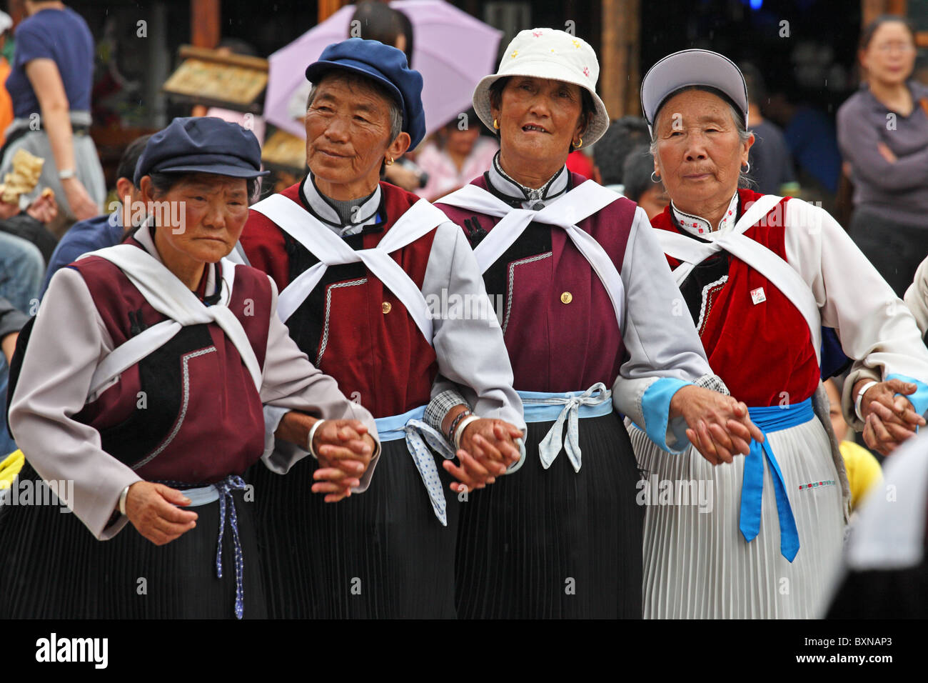 Naxi Frauen tanzen in Straße, Lijiang, Provinz Yunnan, China Stockfoto