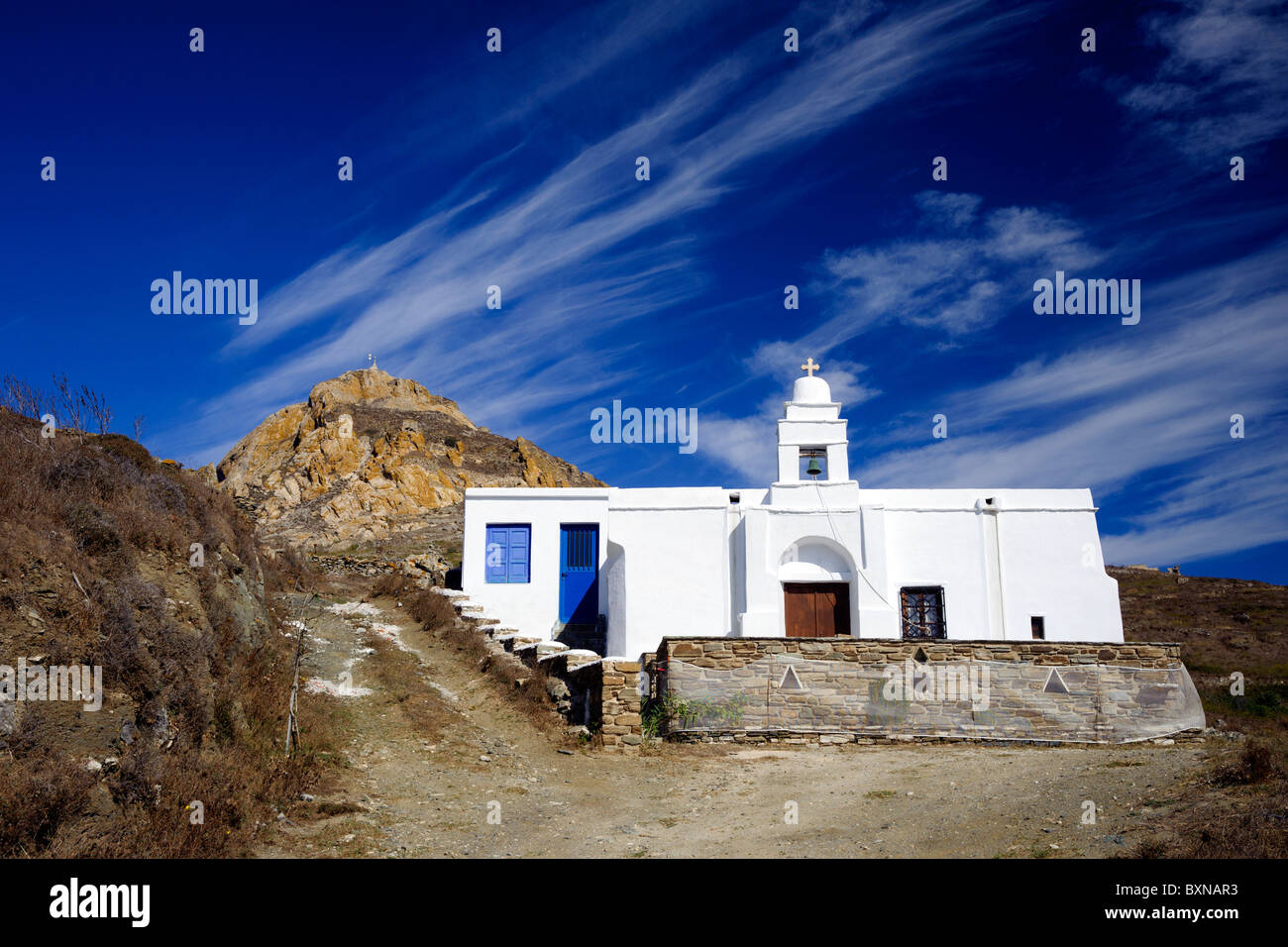 Auf den griechischen Kykladen Insel Tinos, orthodoxe Kapelle in der Nähe von Tripotamos mit Mount Exobourgo im Hintergrund. Stockfoto