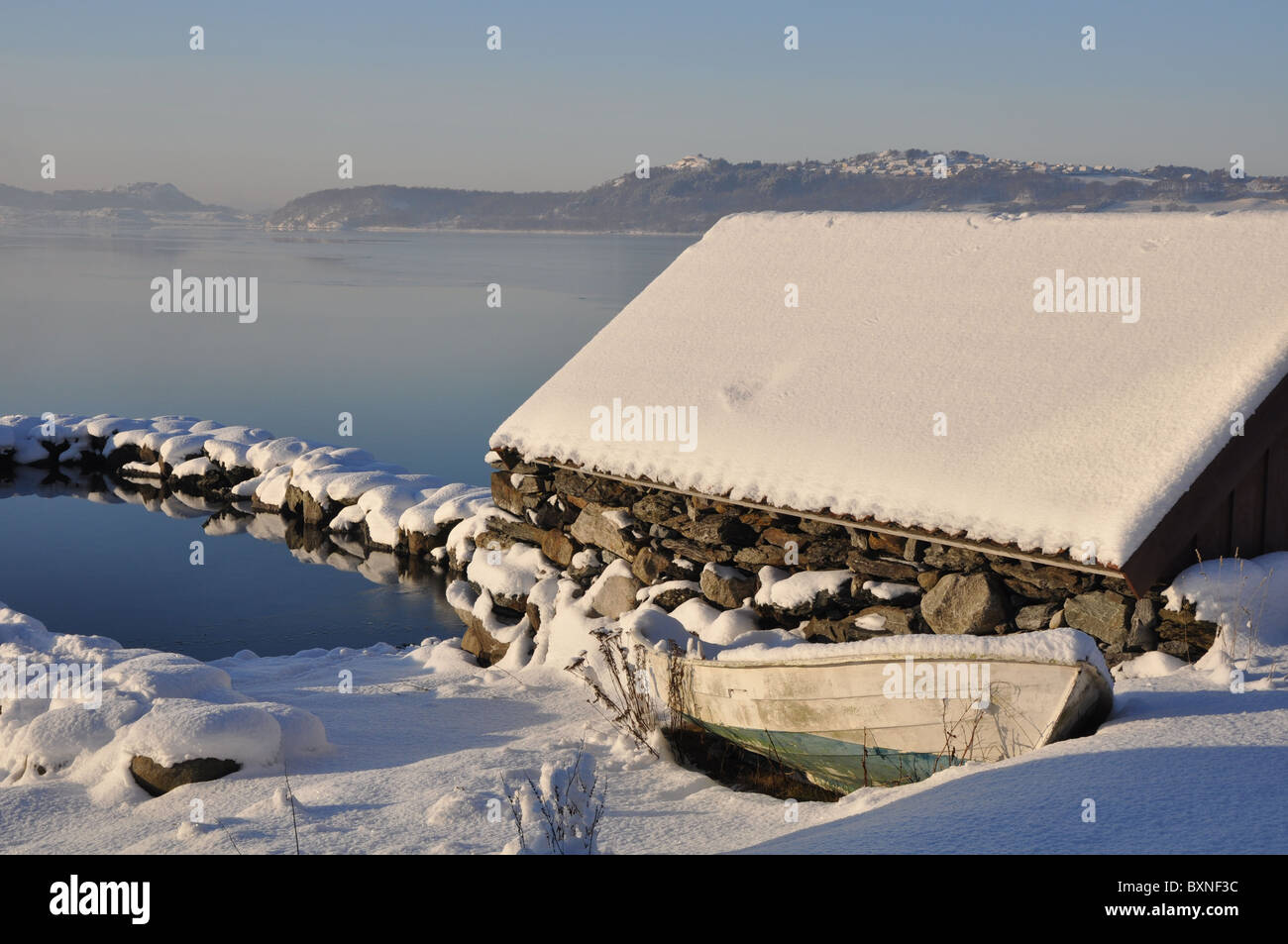 Landschaft am Meer im Winter, Boot, Bootshaus und ein Pier von Stein, Schnee, gefrorene Meer, klare Tag Stockfoto