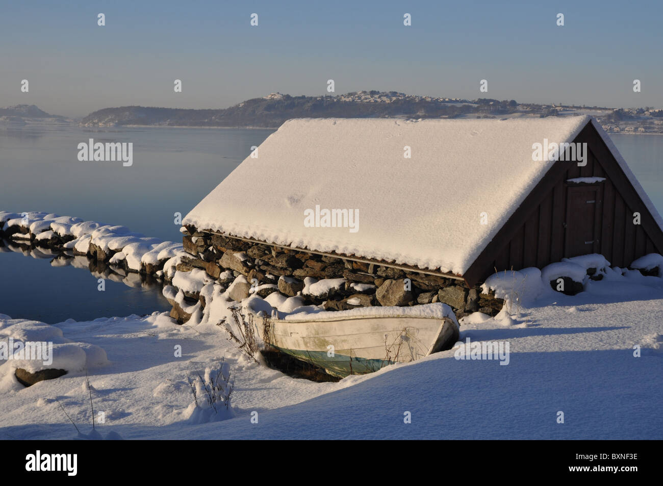 Landschaft am Meer im Winter, Boot, Bootshaus und ein Pier von Stein, Schnee, gefrorene Meer, klare Tag Stockfoto