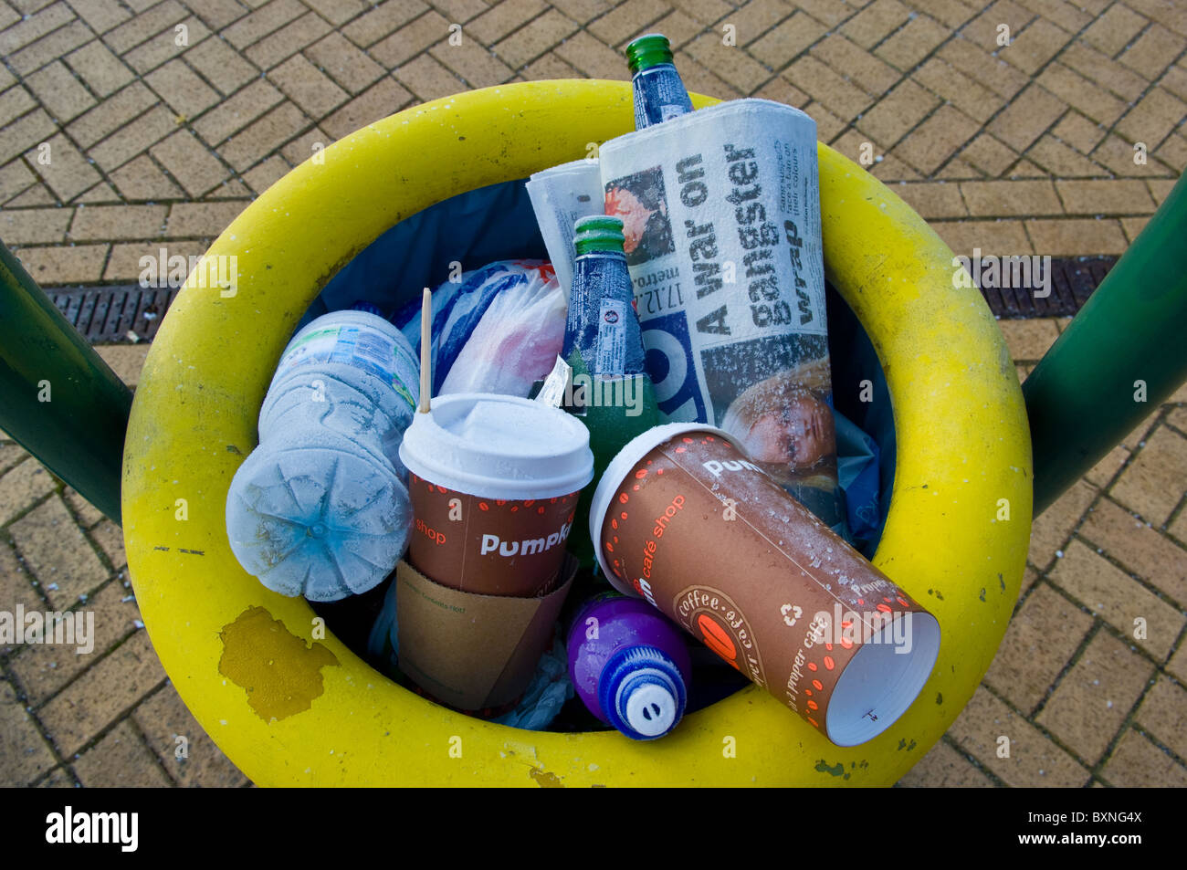 Railway Station Plattform Abfallbehälter voll mit Wertstoffen, Pappbecher, Plastikflaschen und Zeitung. Stockfoto