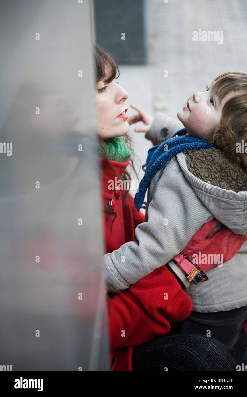Erschöpfte Mutter sitzen mit aktiven zwei Jahre alten Sohn Stockfoto