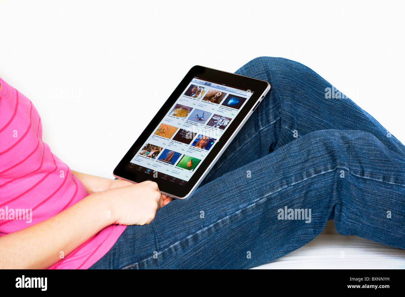 Frau, entspannend, mit einem Apple Mac iPad auf dem Schoß Blick auf Youtube Stockfoto