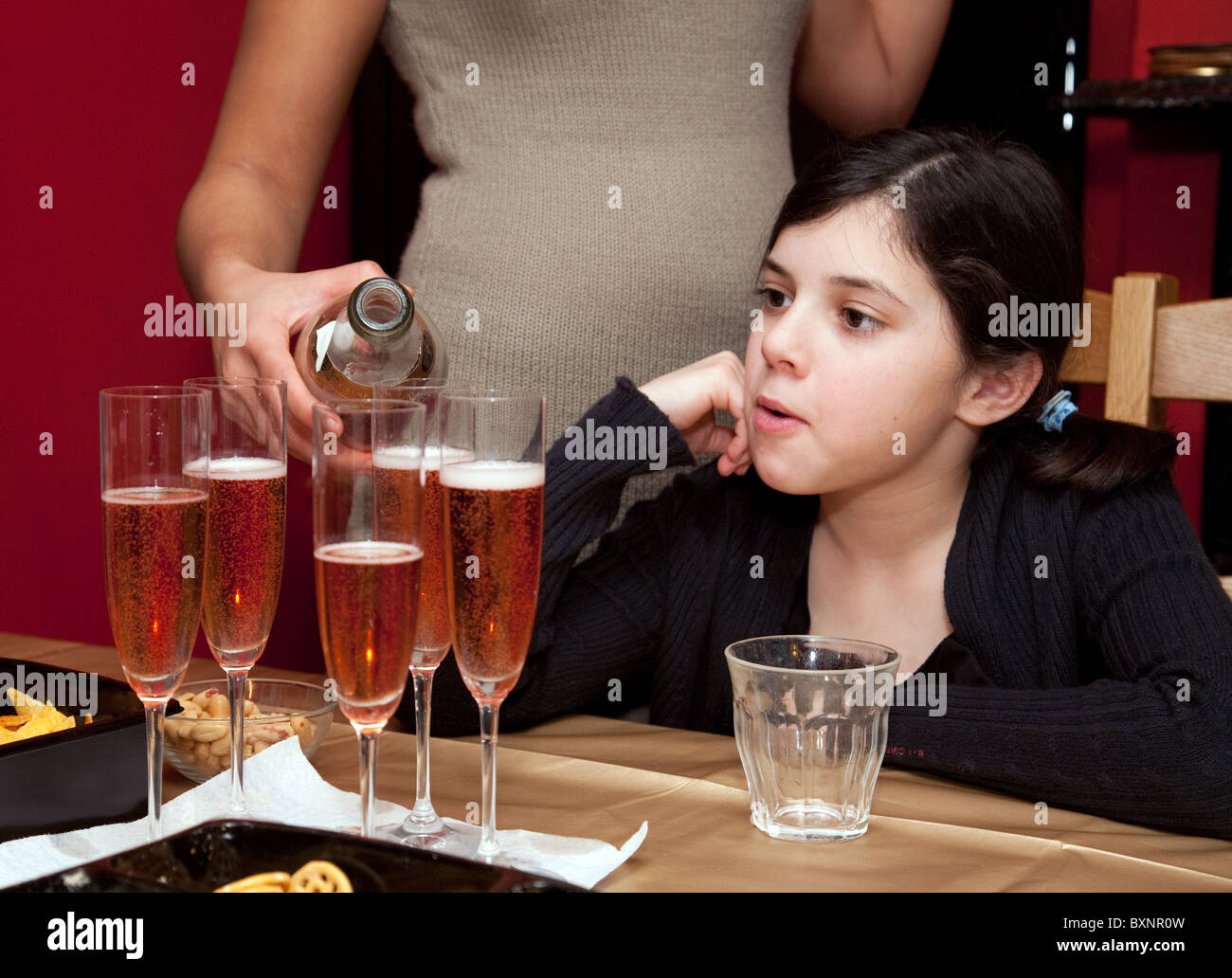 Ein Kind beobachten, wie Champagner ist ausgegossen, London UK Stockfoto