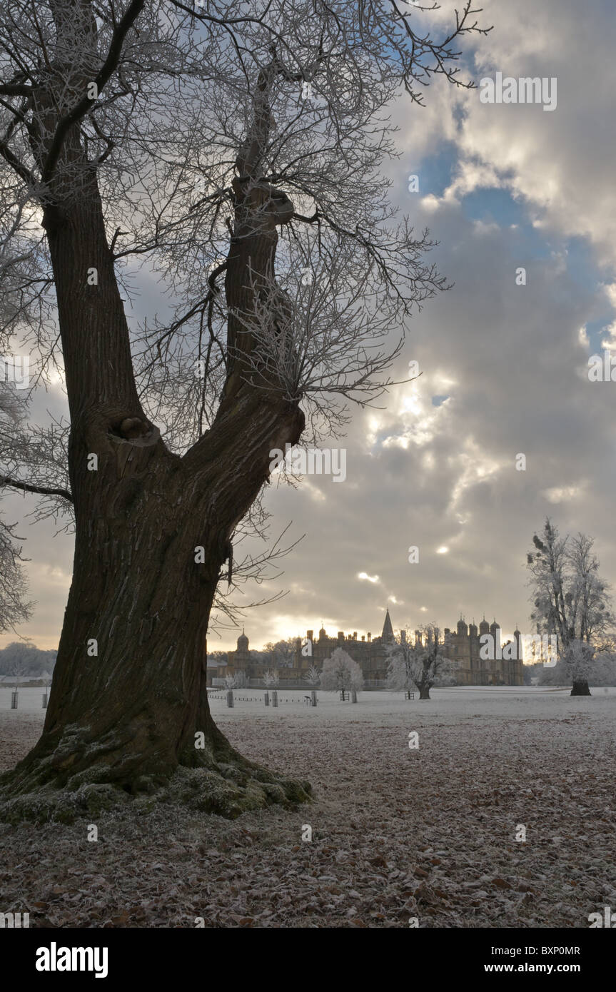 Bodenfrost für Burghley Park als tief stehender Sonne bricht durch den bewölkten Himmel. Stockfoto