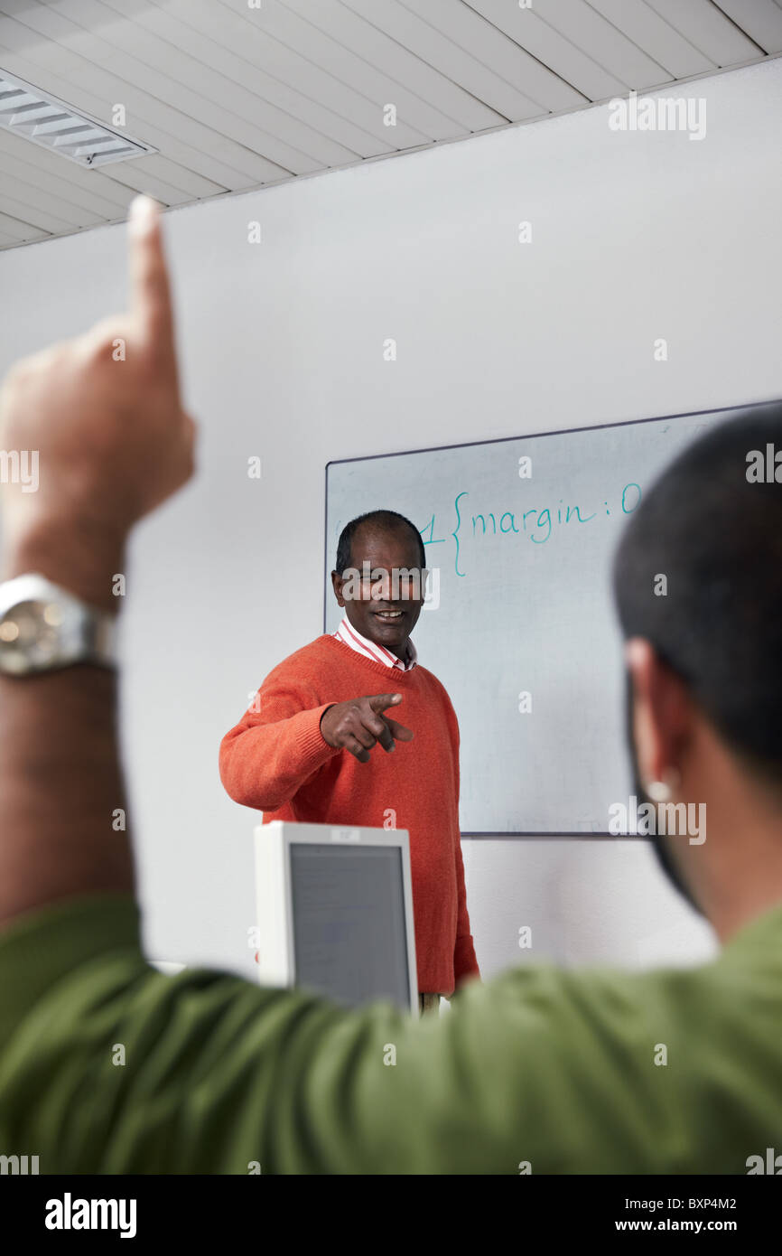 Computerraum mit spanischen Studenten Fragen Frage mit Hand angehoben, um indische Lehrer Reifen. Stockfoto