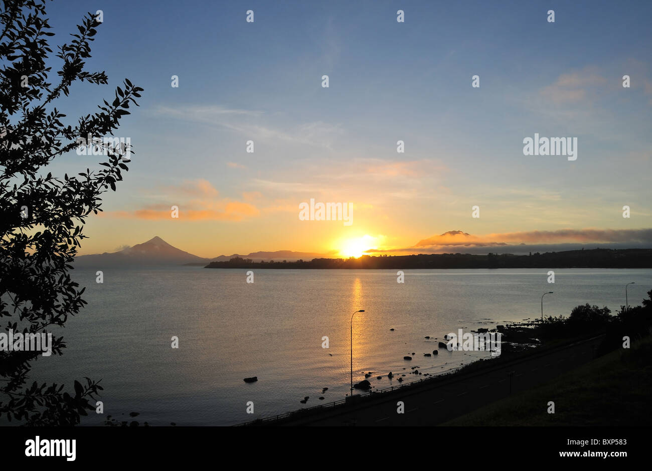 Schein über See Llanquihue, gelbe Sonnenaufgang zwischen Osorno und Calbuco Vulkane, von Puerto Varas Küste gesehen. Chile Stockfoto