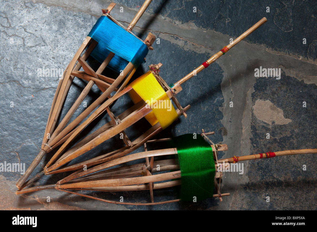 Farbige Seide auf Bambus Spindeln auf dem Webstuhl für die Sari's. Andhra Pradesh, Indien Stockfoto