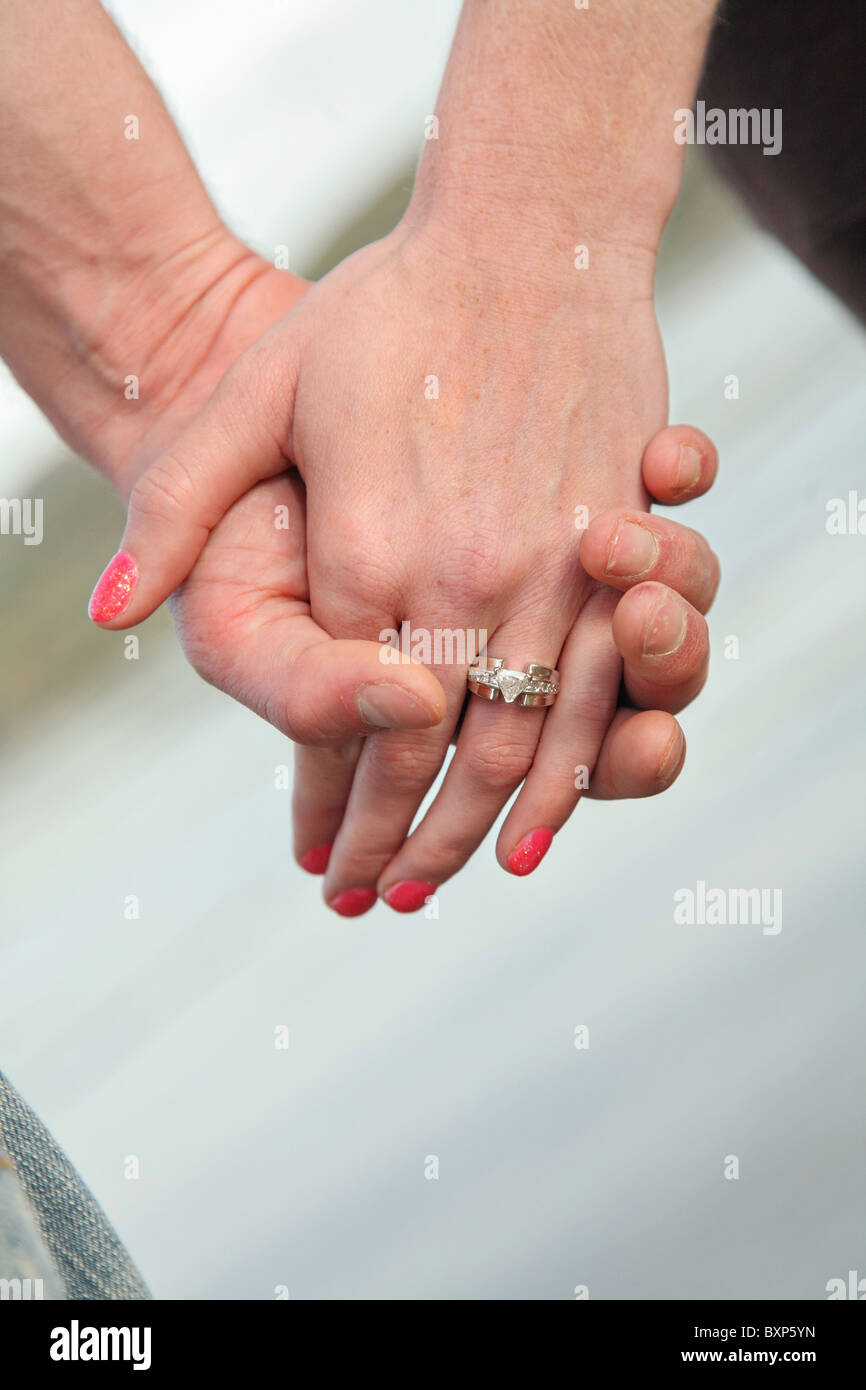 Heterosexuelles Paar Hand in Hand mit Verlobungsring Stockfoto