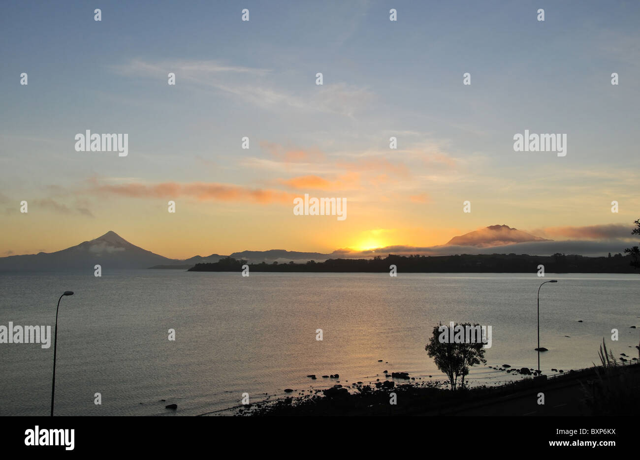 Dawn Blick aus Puerto Varas, der gelbe Sonnenaufgang über dem Wasser des Sees Llanquihue, Osorno bis Calbuco Vulkane, Chile Stockfoto