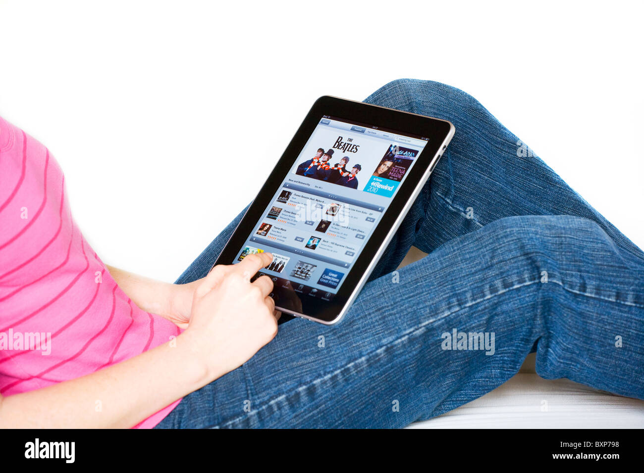 Frau, entspannend, mit einem Apple Mac iPad auf dem Schoß, Online-shopping auf den iTunes store Stockfoto