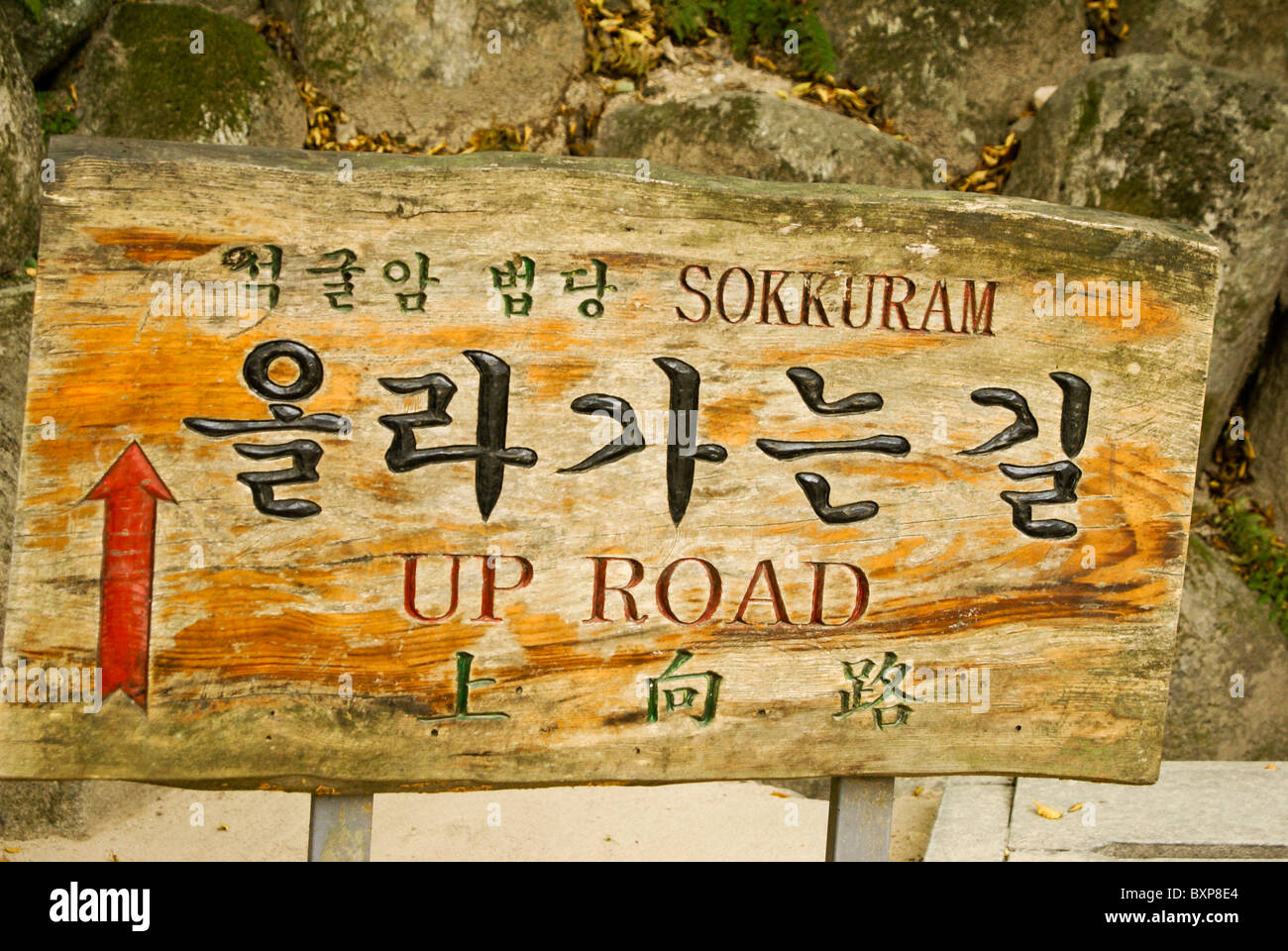 Ein altes bemaltes Holzschild in drei Sprachen (Englisch, Chinesisch, Koreanisch) weist den Weg nach Seokguram (Sokkuram) Grotto, Gyeongju, Südkorea Stockfoto