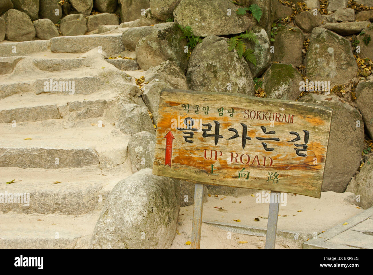 Eine Alte bemalte Holz Schild in drei Sprachen (Englisch, Chinesisch, Koreanisch) weist den Weg zu Seokguram Grotte (Sokkuram), Südkorea Stockfoto