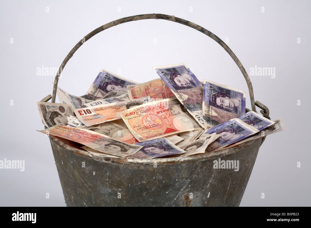 Metall-Eimer voller englischer Währung Stockfoto