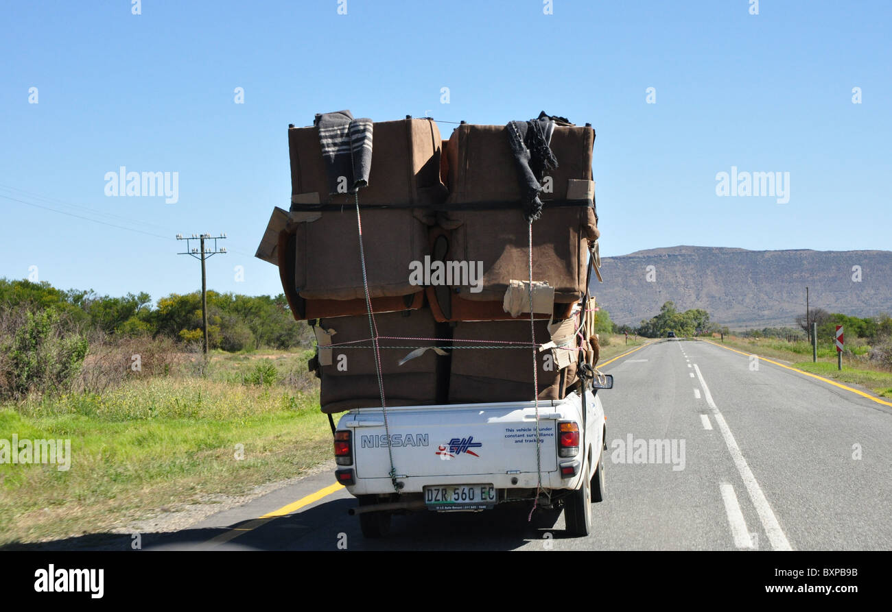 Große Last auf Kleinwagen auf afrikanischen Straßen Stockfoto