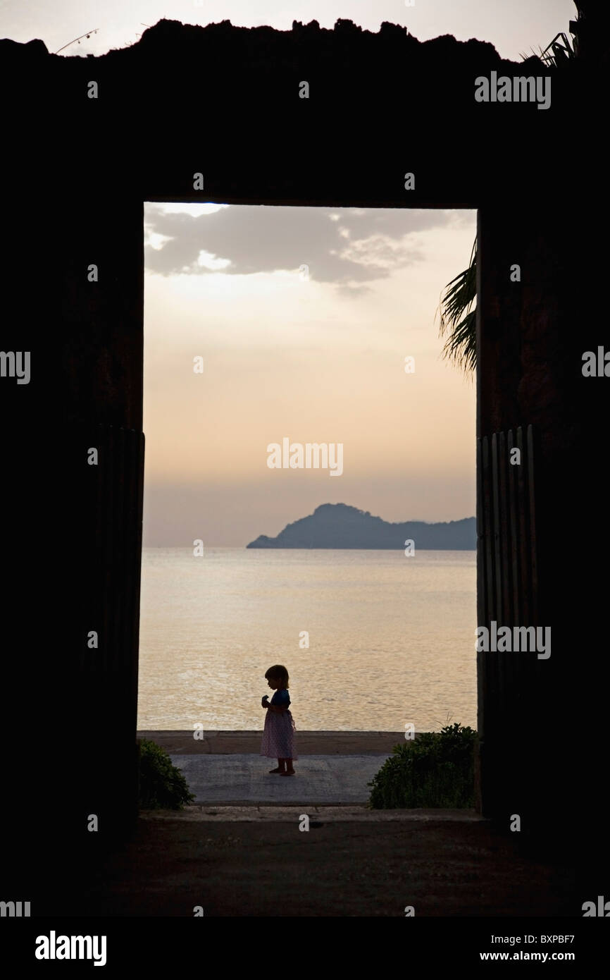 Blick durch ein Tor in die Silhouette eines Mädchens auf Lopud Insel. Stockfoto