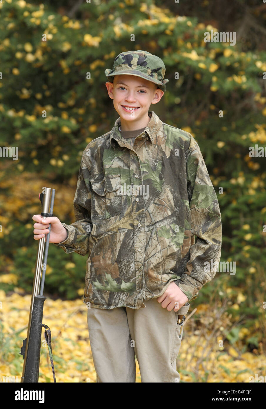 Glücklicher junger Jäger mit Gewehr und Tarnung auf den ersten Hirschjagd Stockfoto
