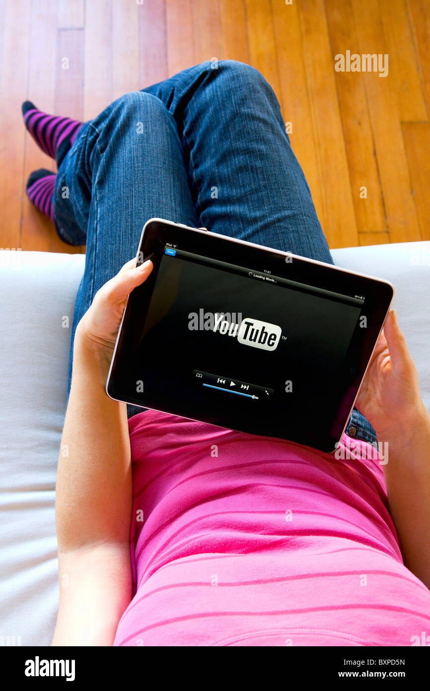 Frau entspannen Verwendung zu Hause eines Apple Mac iPad gerade YouTube auf ihrem Schoß. Stockfoto