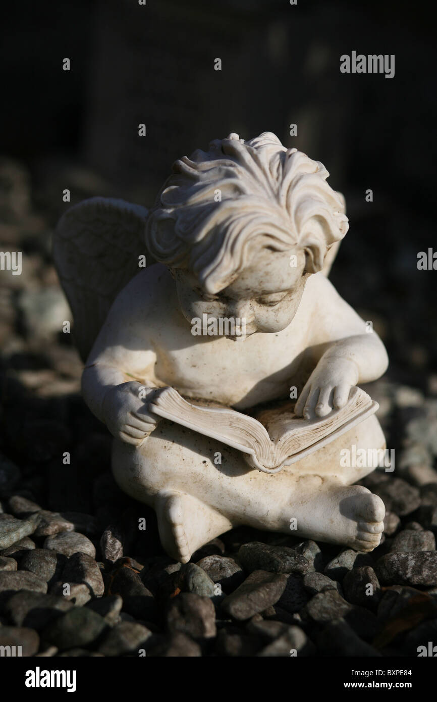 Eine steinernen geflügelten Engel Figur saß auf einem Grab Stockfoto