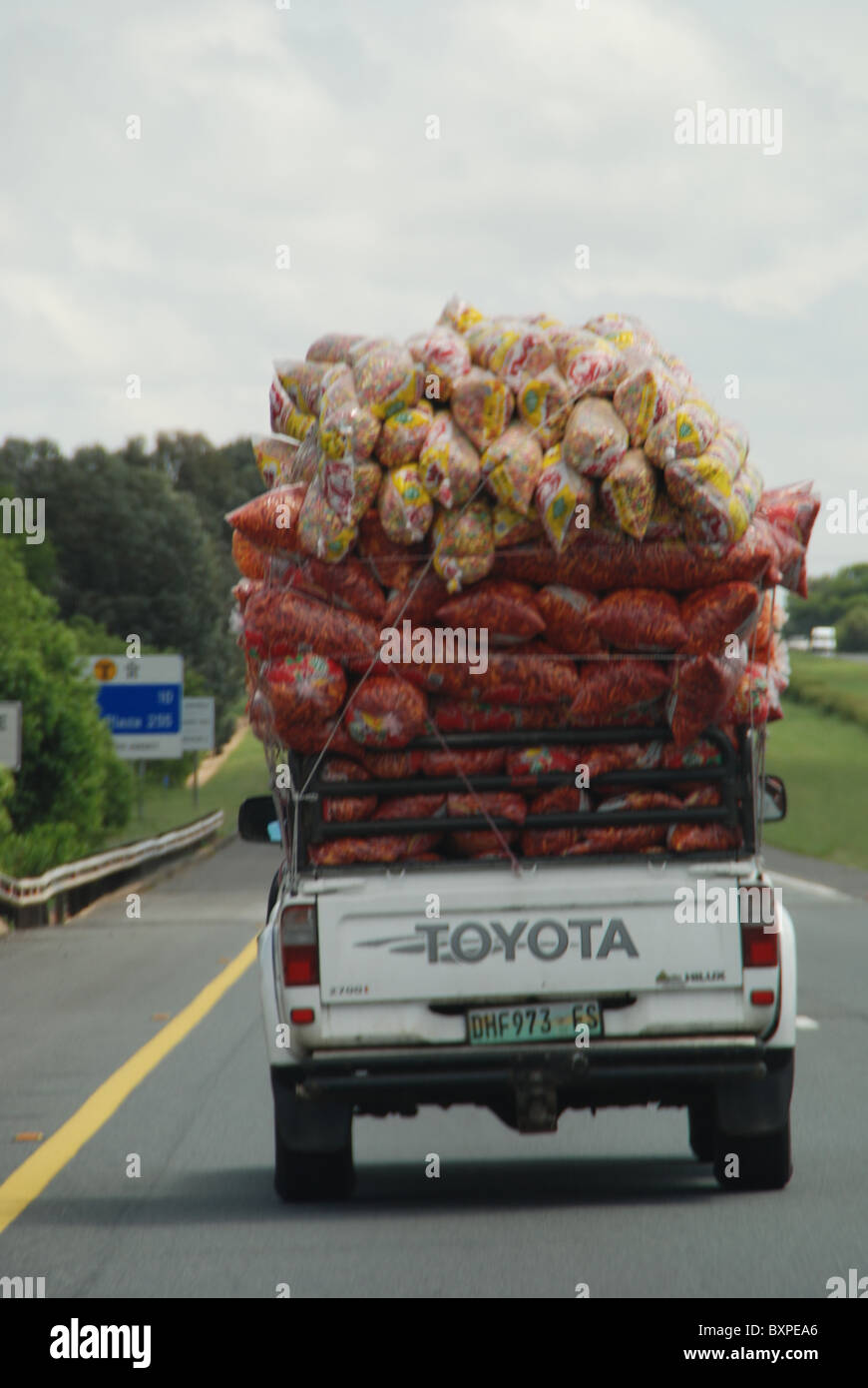 Große Last auf Kleinwagen auf afrikanischen Straßen Stockfoto