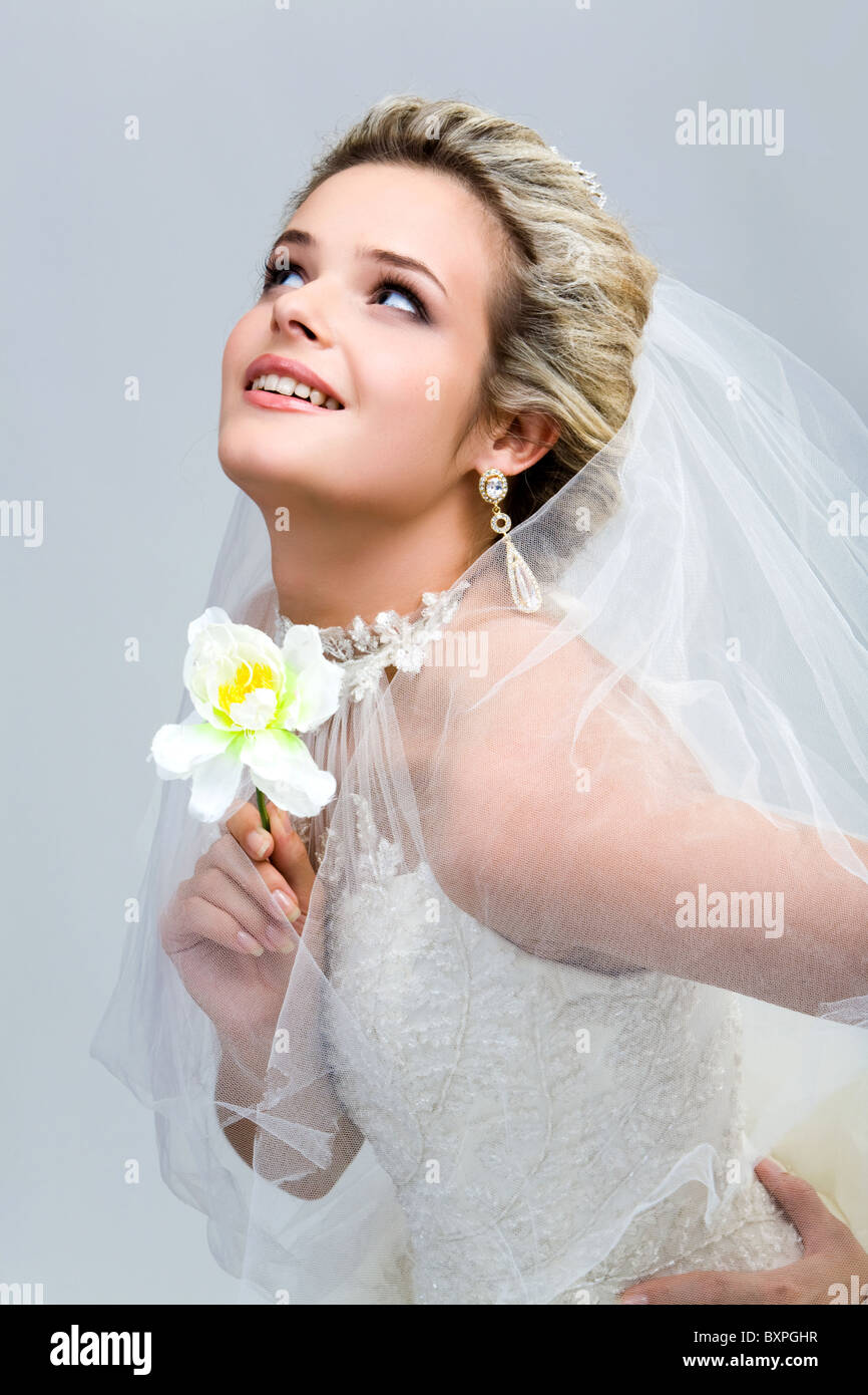 Porträt der modernen Braut mit Orchideen in der hand auf der Suche nach oben Stockfoto