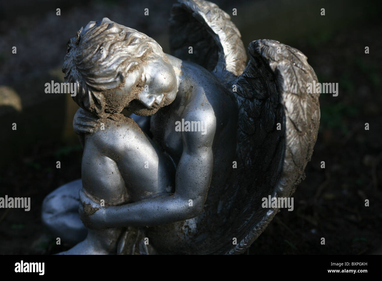 Eine silberne geflügelte Engel Figur saß auf einem Grab Stockfoto