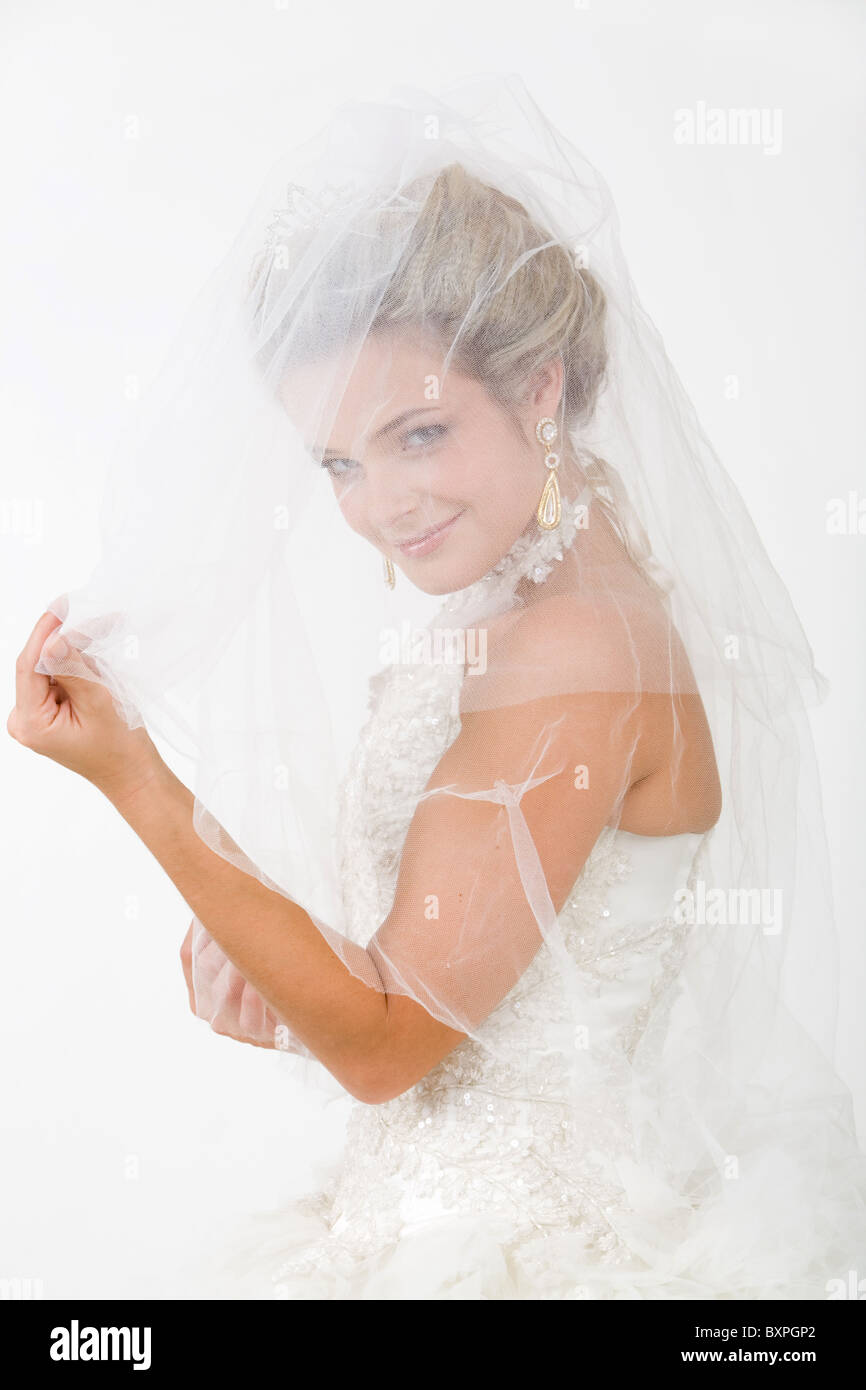 Porträt der glückliche Braut Blick in die Kamera Lächeln durch ihren Schleier Stockfoto