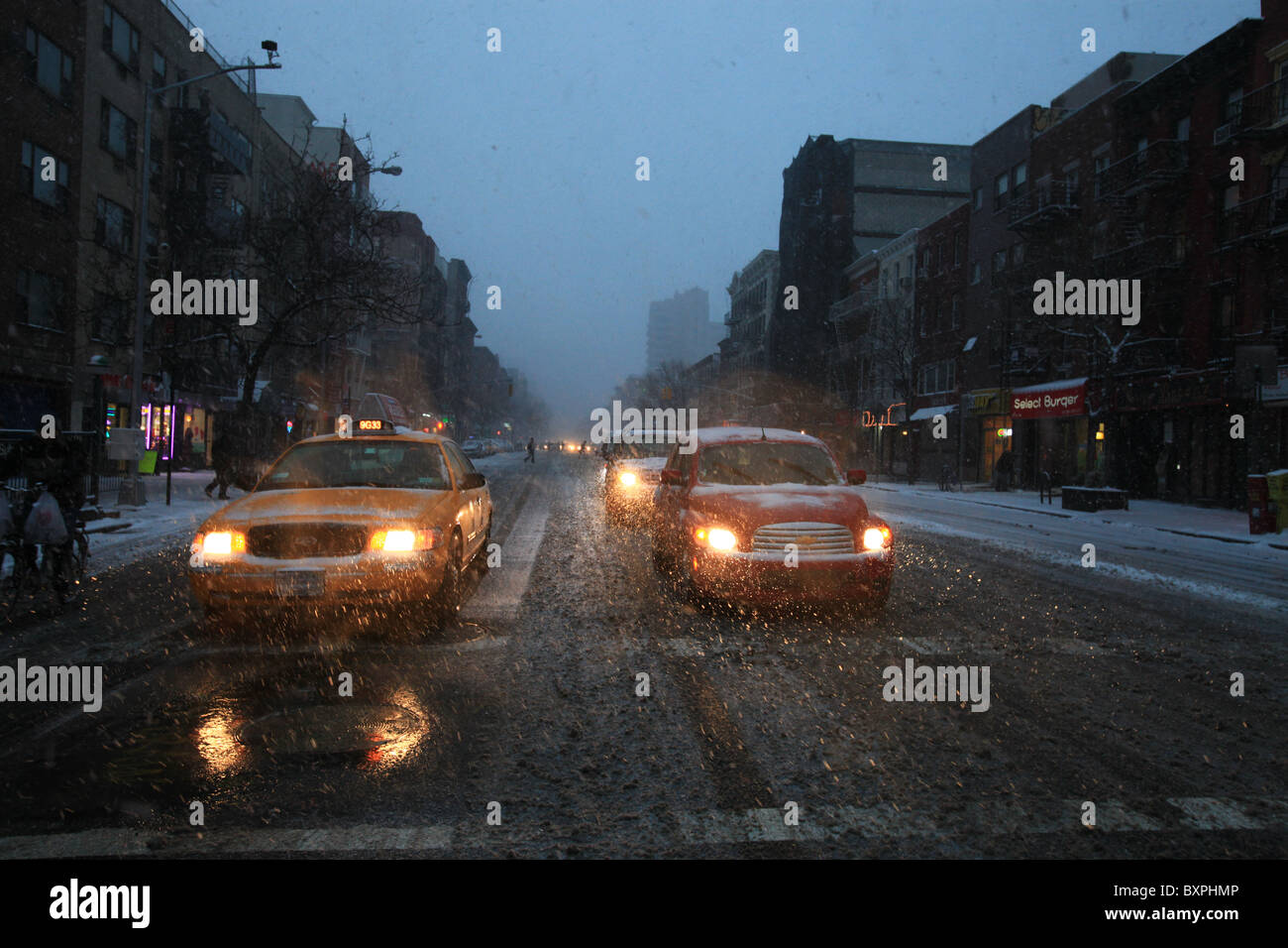Autos und Taxis warten an der Ampel auf der 14th Street, Manhattan, New York, in der großen Schneesturm, der Weihnachten 2010 kam Stockfoto