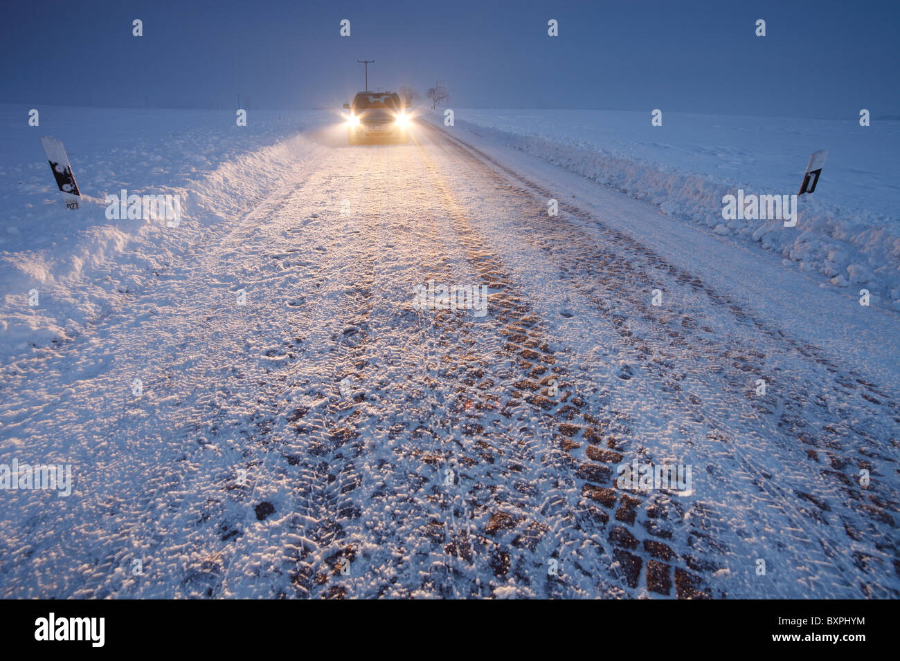 Auto (Toyota Avensis) auf einer verschneiten Landstraße in der Nähe von Halle (Saale), Deutschland Stockfoto