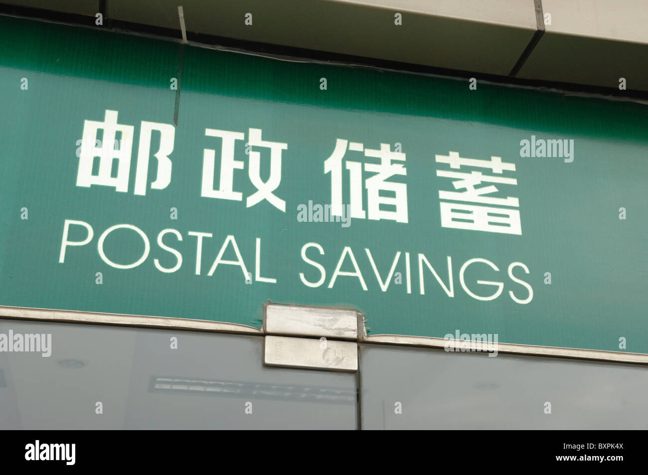 Chinesische Zeichen mit einer englischen Übersetzung außerhalb ein Postamt. Stockfoto