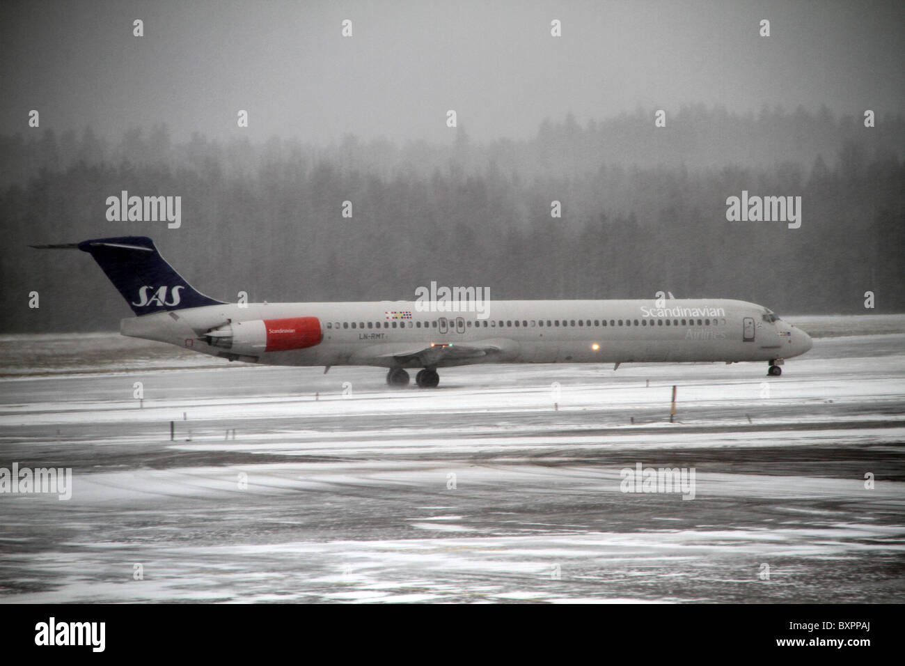 Flughafen Arlanda, Stockholm, Schweden. Ein SAS-Flugzeug auf dem Rollfeld in einem Schnee gebunden und nebligen Tag am Flughafen Arlanda. Stockfoto