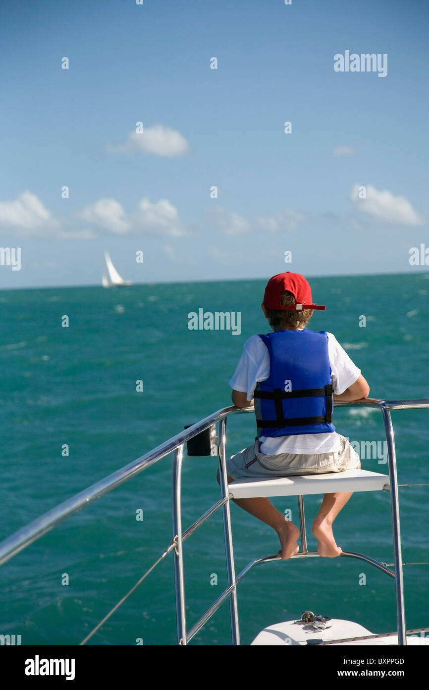 Junge In Schwimmweste sitzen am Rand des Segelboot Stockfoto
