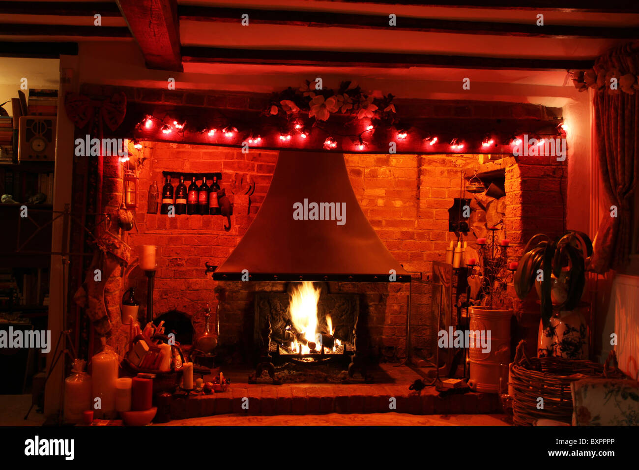 Ein Inglenook Kamin in einem englischen Landhaus an Weihnachten dekoriert. Stockfoto