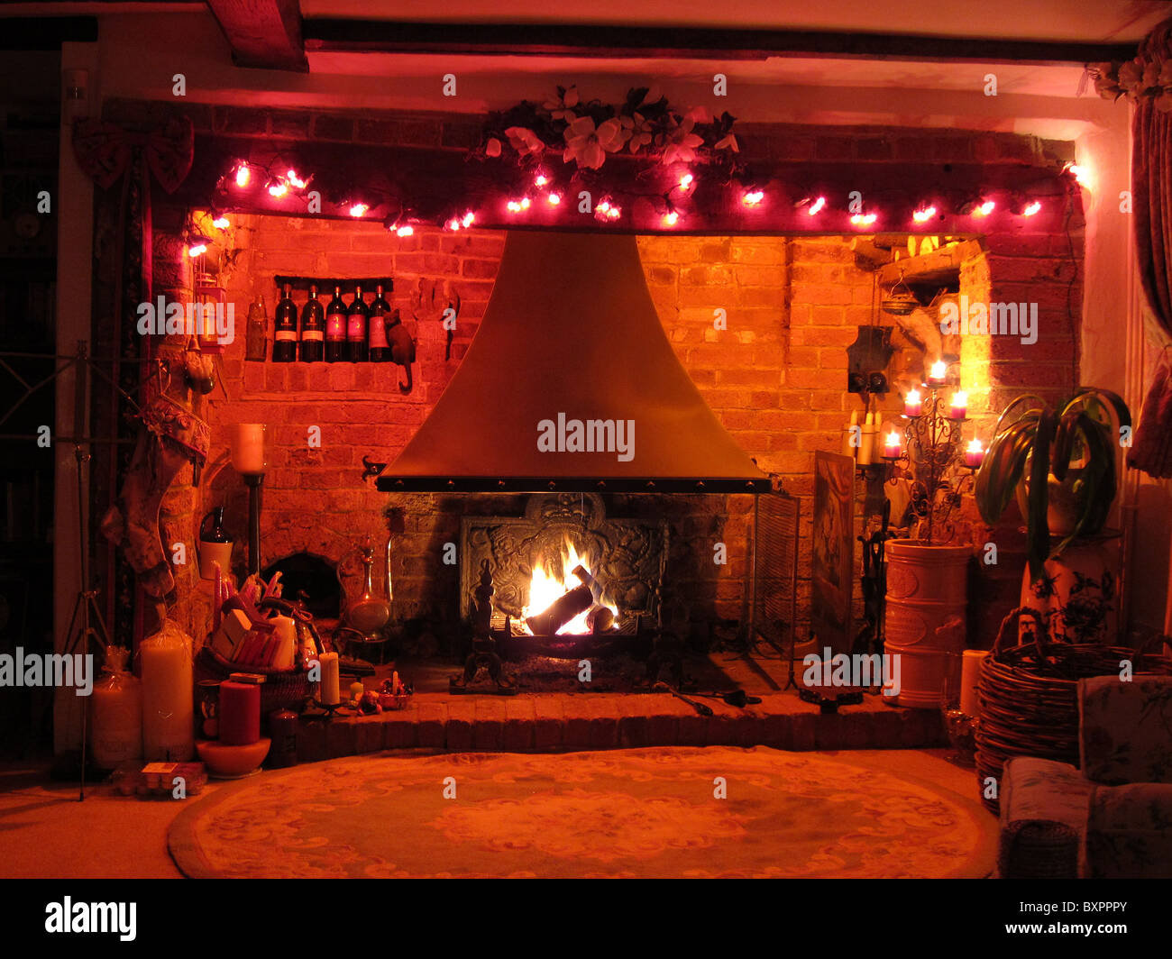 Ein Inglenook Kamin in einem englischen Landhaus an Weihnachten dekoriert. Stockfoto