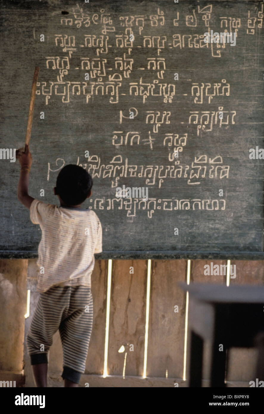 Junge zeigt auf schriftlich auf einer Tafel In einer ländlichen Schule Stockfoto