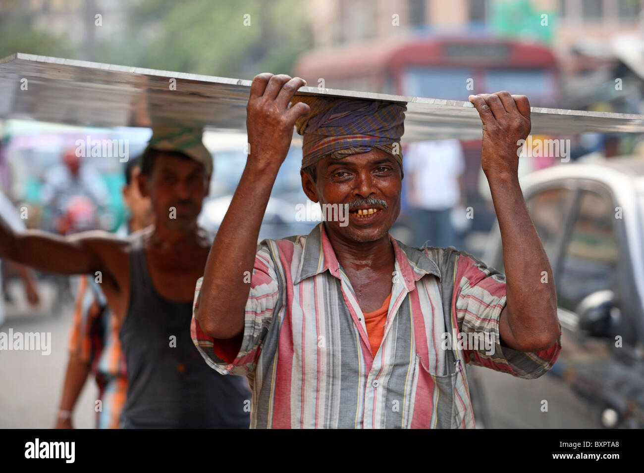 Indischer Mann trägt Last auf dem Kopf in der Straße, Kalkutta, Indien Stockfoto