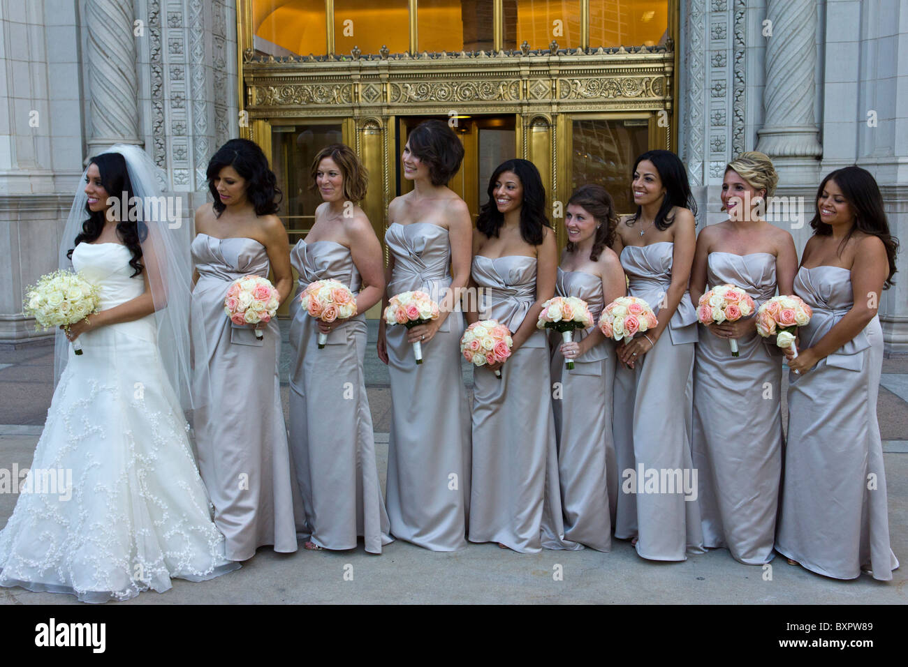 Braut und Mädchen der Ehre posiert außen Wrigley building, Chicago Stockfoto