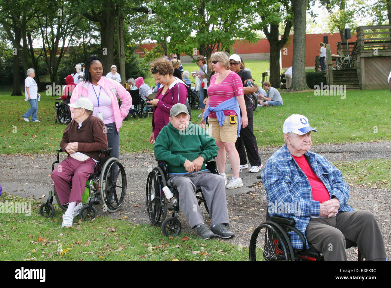 Drei ältere Männer Teilnehmer im Rollstuhl. Mit Frauen-Betreuer. Alzheimer Speicher zu Fuß. Zu Fuß zum Ende Alzheimer. Stockfoto