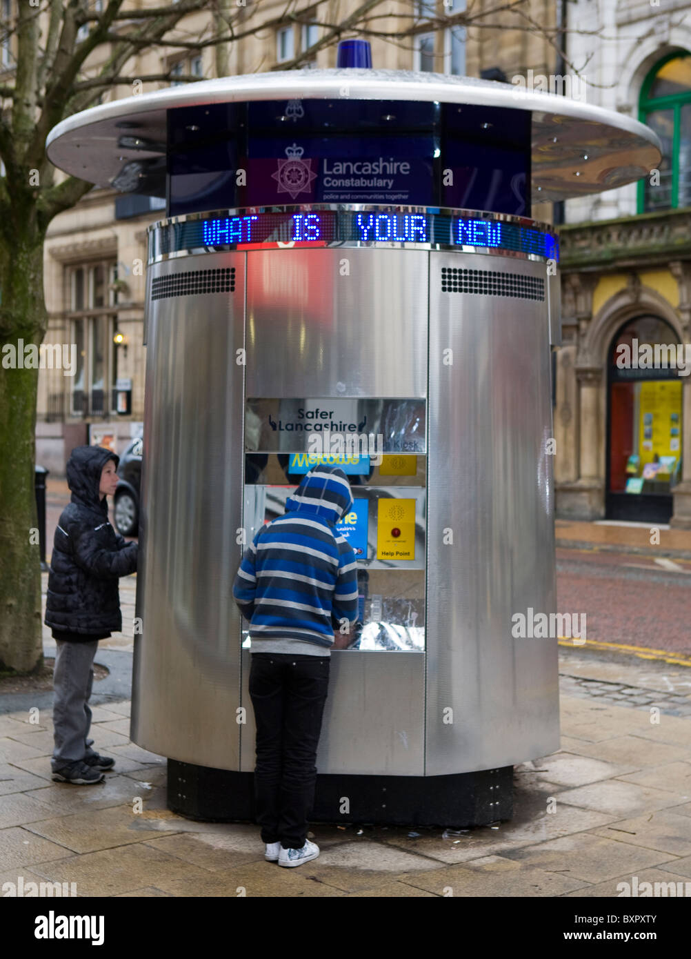 Zwei Kinder betrachten Polizei Informations-Kiosk oder Tardis, Stadtzentrum Preston, Lancashire, UK Stockfoto