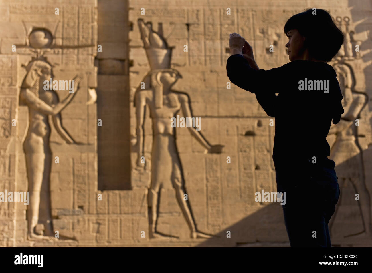 Silhouette der Touristen fotografieren vor großen Reliefs an Wänden des zweiten Pylon Stockfoto