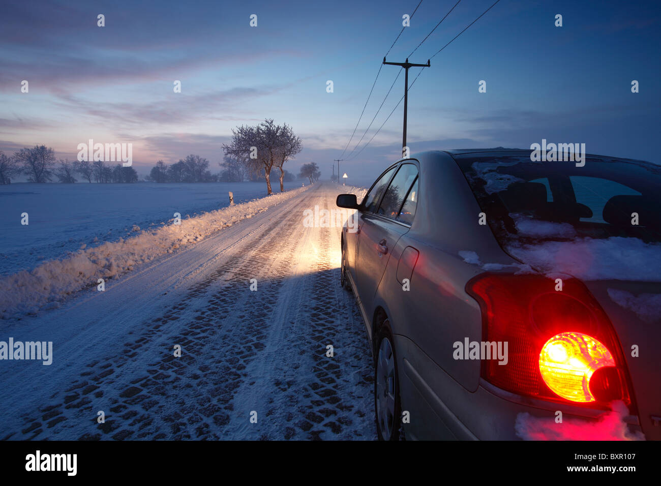 Auto (Toyota Avensis) auf einer verschneiten Landstraße in der Nähe von Halle (Saale), Deutschland Stockfoto