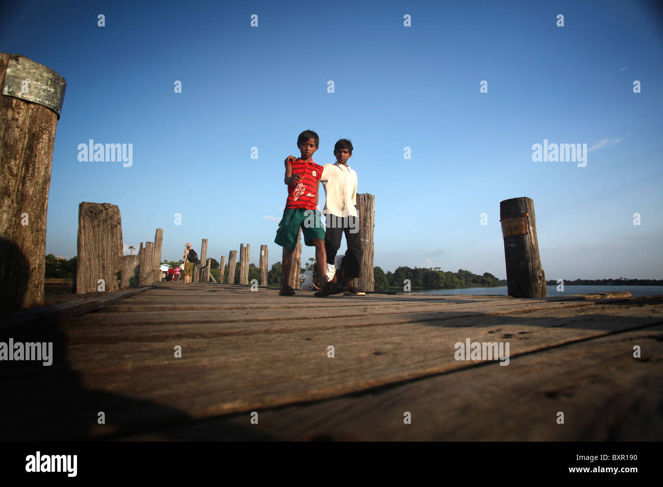 Kinder der Teak U Bein Brücke, die Taugthaman See in Amarapura in der Nähe von Mandalay in Myanmar erstreckt. Stockfoto