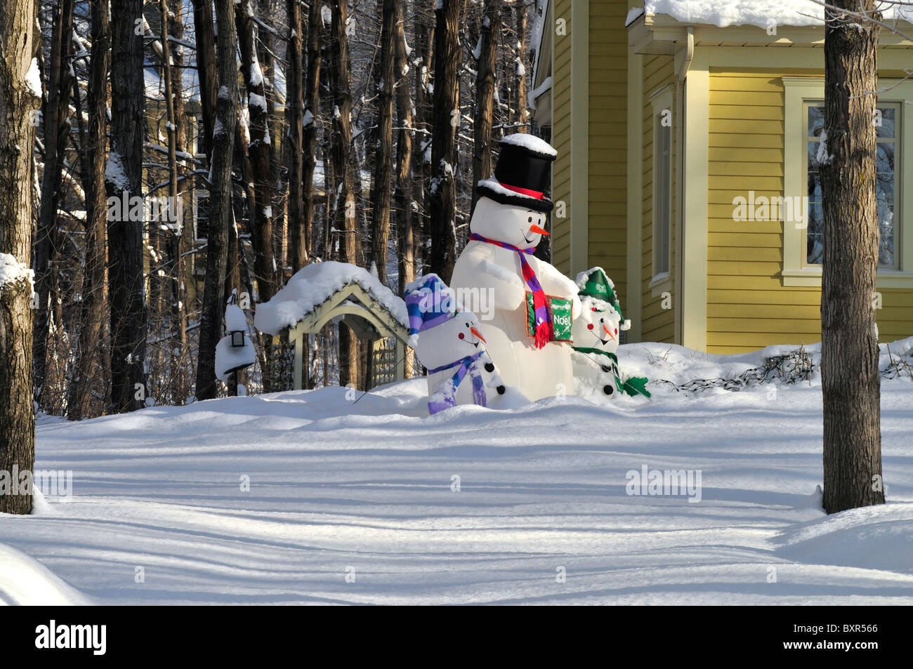 Ein Schneemann mit seinen Gefährten zieren die Seite eines Wohnhauses in Quebec, Kanada im Winter. Stockfoto